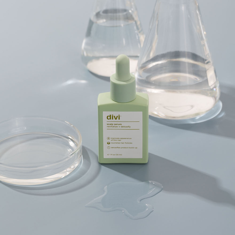scalp serum bottle with beakers in background