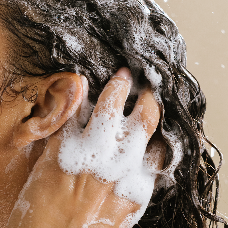 close up photo of hand shampooing hair