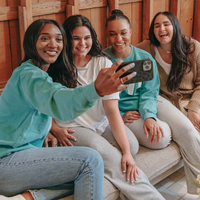 girl taking selfie with friends in divi crewneck